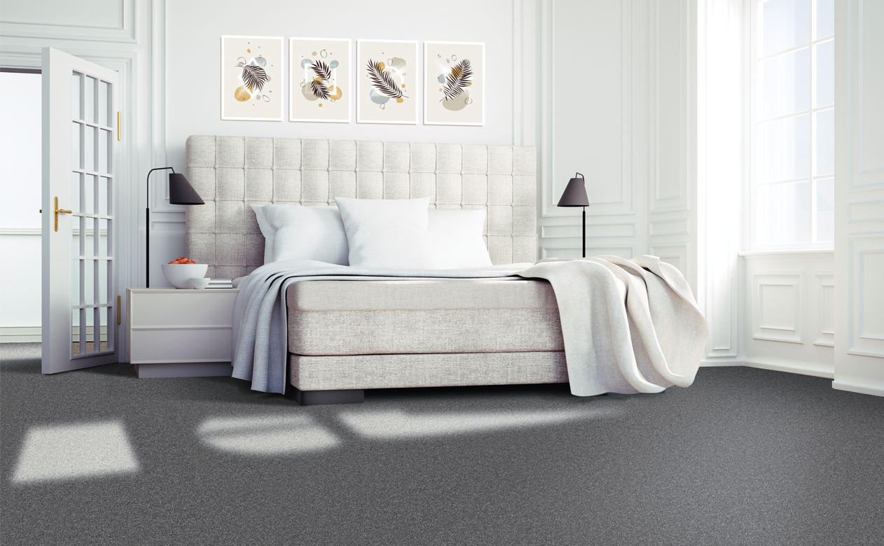 Dark grey carpet in bedroom with plush headboard 